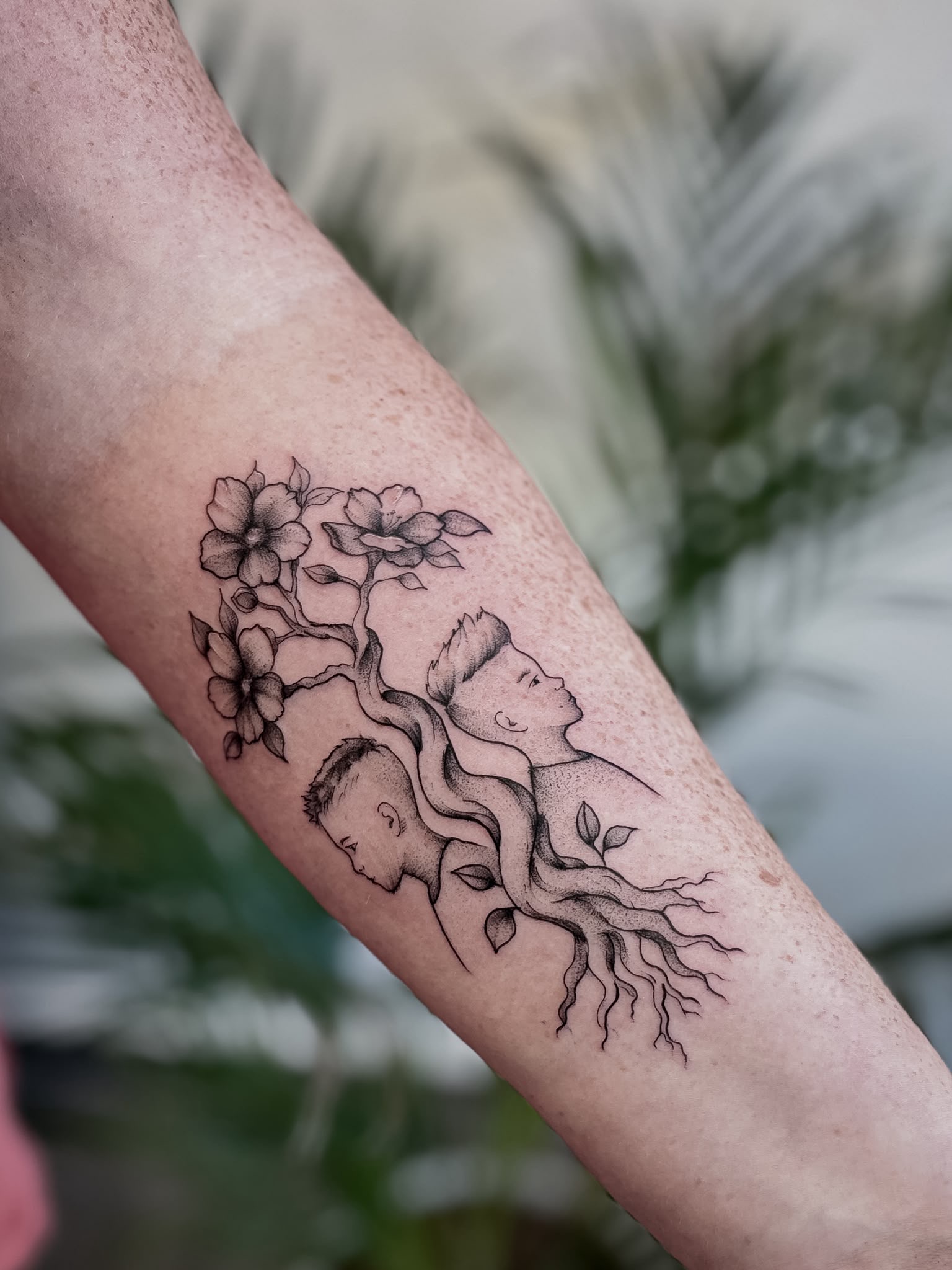 Fine-Line Familientattoo mit Porträts, Wurzeln und Blüten